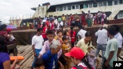 Fleeing Buddhist Rakhine residents arrive by ship from the unrest in Maungdaw region at the jetty, Aug. 29, 2017, in Sittwe, Rakhine State, western Myanmar. 