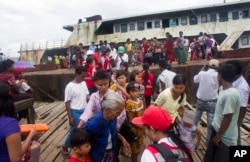Fleeing Buddhist Rakhine residents arrive by ship from the unrest in Maungdaw region at the jetty, Aug. 29, 2017, in Sittwe, Rakhine State, western Myanmar.