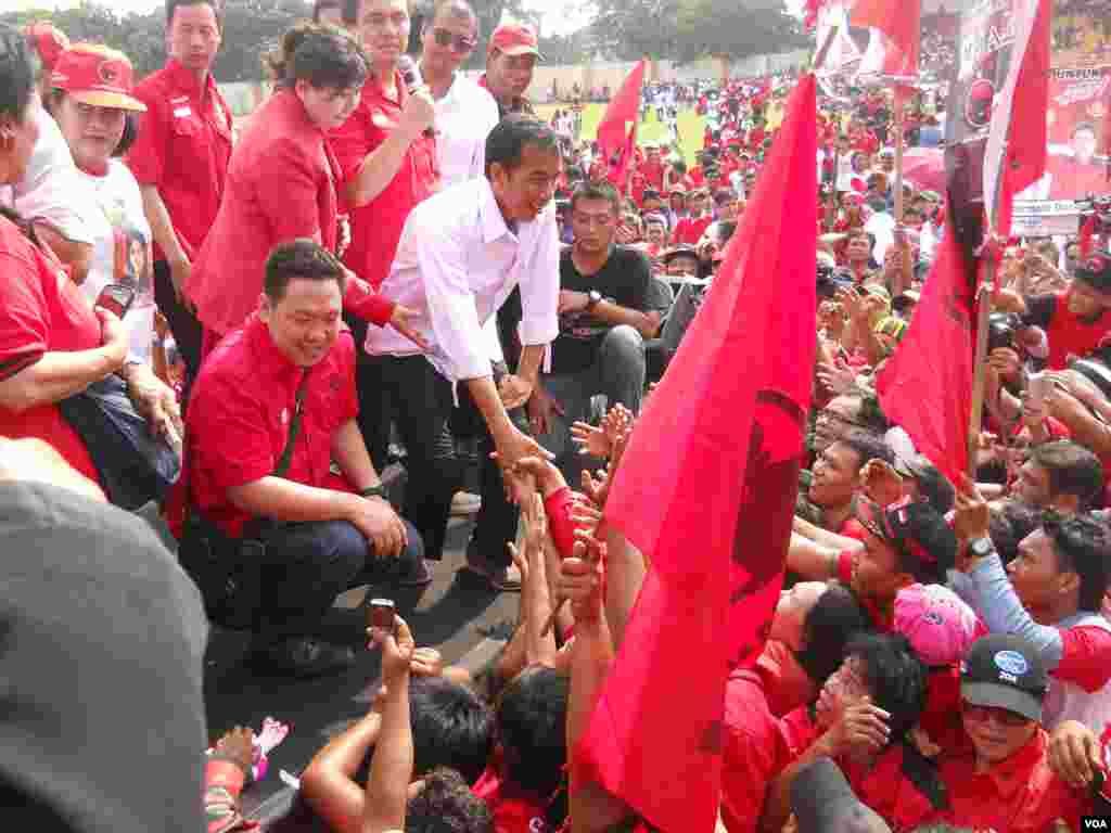 Calon presiden dari Partai Demokrasi Indonesia Perjuangan, Gubernur Jakarta Joko Widodo alias Jokowi, menyalami para pendukung dalam kampanye terbuka Minggu (16/3) di Lapangan Gelanggang Olah Raga Cendrawasih, Cengkareng, Jakarta Barat. (VOA/Andylala Waluyo)