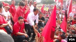 Calon Presiden dari PDI Perjuangan Jokowi bersalaman dengan para ribuan simpatisan dan kader PDI Perjuangan yang menghadiri kampanye terbuka Minggu 16 Maret 2014 di Gelanggang Olah Raga Cendrawasih Cengkareng Jakarta. (VOA/Andylala Waluyo)