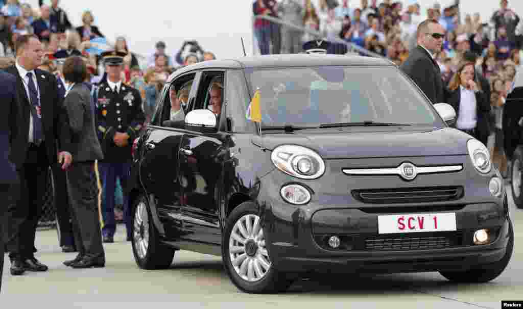 Pope Francis waves from a Fiat 500 model after being driven from Joint Base Andrews outside Washington, Sept. 22, 2015. 