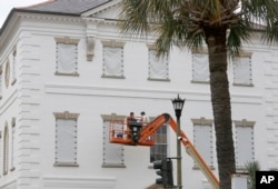 Workers cover the windows of the historic Charleston County Courthouse in Charleston, South Carolina, in preparation for the advancing Hurricane Florence, Sept. 11, 2018.