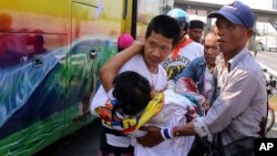 Anti-government protesters carry injured protester from a bus to an ambulance after an attack by suspected gunmen while on their way back from a protest in Bangkok, Thailand, April 1, 2014. 