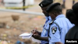 Policemen take down evidence at the scene of a car bomb attack in Nyanya, Abuja, May 2, 2014. 