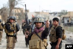 FILE - Members of Iraq's elite counter-terrorism service secure the central Ramadi’s Hoz neighborhood after Islamic State jihadists abandon their last stronghold in the Anbar province capital, Dec. 27, 2015.