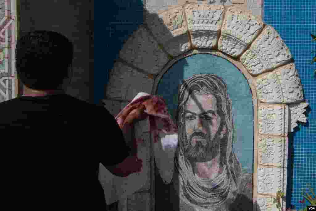 Lukisan dinding yang menggambarkan Ali, ayah Hussein dan menantu Nabi Muhammad, yang dianggap oleh komunitas Muslim Syiah sebagai imam pertama. (VOA/J. Owens)