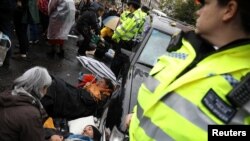 Activistas atados a un vehículo durante la protesta Rebelión de la Extinción en Londres, el 7 de octubre de 2019. Reuters/Marika Kochiasvillii.