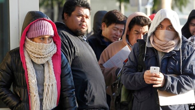 Tư liệu - Người nhập cư chống chọi thời tiết lạnh đứng xếp hàng bên ngoài văn phòng Sở quản lý Xe Cơ giới California để đăng ký bằng lái xe ở Stanton, California, ngày 2 tháng 1, 2015. 