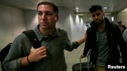 19일 미국 기자 글렌 그린월드(왼쪽)가 그의 동성 연인 데이빗 미란다와 함께 리오데 자네이로 국제공항을 빠져나오고 있다.