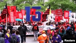FILE - Cooks, cashiers and other minimum wage earners join anti-Trump activists on a march for an increase in the minimum wage during a “March on McDonald’s” in Chicago, Illinois, May 23, 2017. 