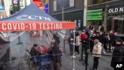 People wait to get tested for COVID-19 at a mobile testing site in Times Square on Dec. 17, 2021, in New York. 