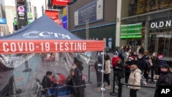FILE - People wait to get tested for COVID-19 at a mobile testing site in Times Square on Dec. 17, 2021, in New York. 