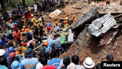 Rescuers search for people trapped in a landslide caused by Typhoon Mangkhut at a small-scale mining camp in Itogon, Benguet, in the Philippines, Sept. 17, 2018.