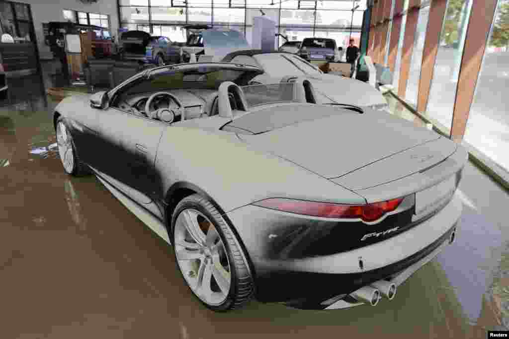 A new Jaguar convertible stands in a showroom covered with a thin film of mud after the floods of the nearby Danube river subsided in Fischerdorf, Germany, June 9, 2013.
