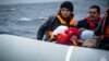 FILE - Migrants on a dinghy arrive from the Turkish coast at the Greek island of Lesbos, Jan. 29, 2016.