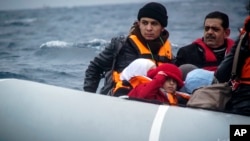 FILE - Migrants on a dinghy arrive from the Turkish coast at the Greek island of Lesbos, Jan. 29, 2016.