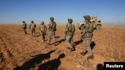 FILE - U.S. and Turkish soldiers conduct the first-ever combined joint patrol outside Manbij, Syria, Nov. 1, 2018, in this U.S. Army handout photo provided by Reuters.