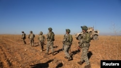 FILE - U.S. and Turkish soldiers conduct the first-ever combined joint patrol outside Manbij, Syria, Nov. 1, 2018, in this U.S. Army handout photo provided by Reuters.