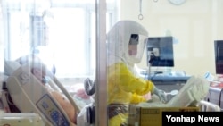 19일 메르스 환자가 격리 치료 중인 서울 국립중앙의료원에서 방호복을 입은 병원 관계자가 업무를 보고 있다. 