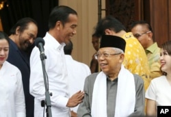 Petahana Presiden Joko Widodo (tengah kiri) bercanda dengan cawapres Ma’ruf Amin (tengah kanan) dalam konferensi pers setelah pertemuan dengan partai koalisi di Jakarta, 18 April 2019.