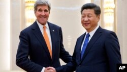 美国国务卿克里（左）在北京人大会堂与中国国家主席习近平举行会谈前握手。（2016年1月27日）