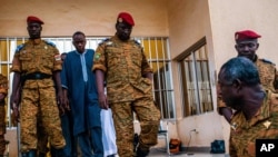 Burkina Faso Lt. Col. Issac Yacouba Zida, center, leaves a government building after meeting with political leaders in Ouagadougou, Burkina Faso, Nov. 4, 2014. 