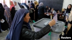 An Afghan woman casts her vote during parliamentary elections at a polling station in Kabul, Afghanistan, Oct. 20, 2018. 