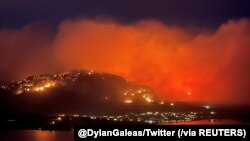 Asap membubung dari api kebakaran hutan tampak di Highway 3 dekat Kota Osoyoos, British Columbia, Kanada, 20 Juli 2021. (Foto: Twitter @DylanGaleas via Reuters)