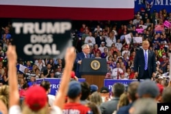 Republican Senate candidate, current West Virginia Attorney General Patrick Morrisey, speaks as President Donald Trump listens during a rally, Aug. 21, 2018, at the Civic Center in Charleston W.Va.