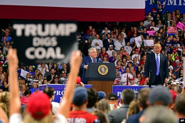 Republican Senate candidate, current West Virginia Attorney General Patrick Morrisey, speaks as President Donald Trump listens during a rally, Aug. 21, 2018, at the Civic Center in Charleston W.Va.