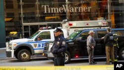 An officer keeps watch in front of the Time Warner Building, where NYPD personnel removed an explosive device Wednesday, Oct. 24, 2018, in New York.