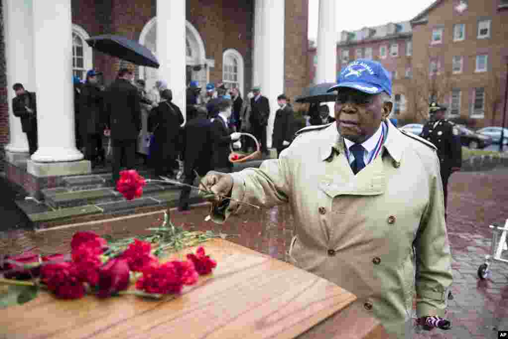 Tuskegee Airman Eugene J. Richardson Jr., places a flower on the casket containing the remains of his comrade John L. Harrison, Jr., after Harrison&#39;s a funeral mass in Philadelphia. Harrison Jr. became one of America&#39;s first black military airmen, one of nearly 1,000 pilots who trained as a segregated unit with the Army Air Forces at an airfield near Tuskegee, Alabama.