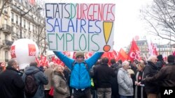 Un manifestant brandit une banderole mentionnant "Etat d'urgence : Salaires et emploi" lors d’une manifestation à Paris, 26 janvier 2016. 