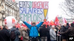 Un manifestant brandit une banderole mentionnant "Etat d'urgence : Salaires et emploi" lors d’une manifestation à Paris, 26 janvier 2016.