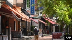 新加坡一名戴口罩的男子走在外買餐廳的巷子裡。(2020年5月11日)