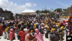 Somalis from southern Somalia receive food distributed by the Muslim Aid Organization in Mogadishu, Somalia, Thursday, Aug. 4, 2011.