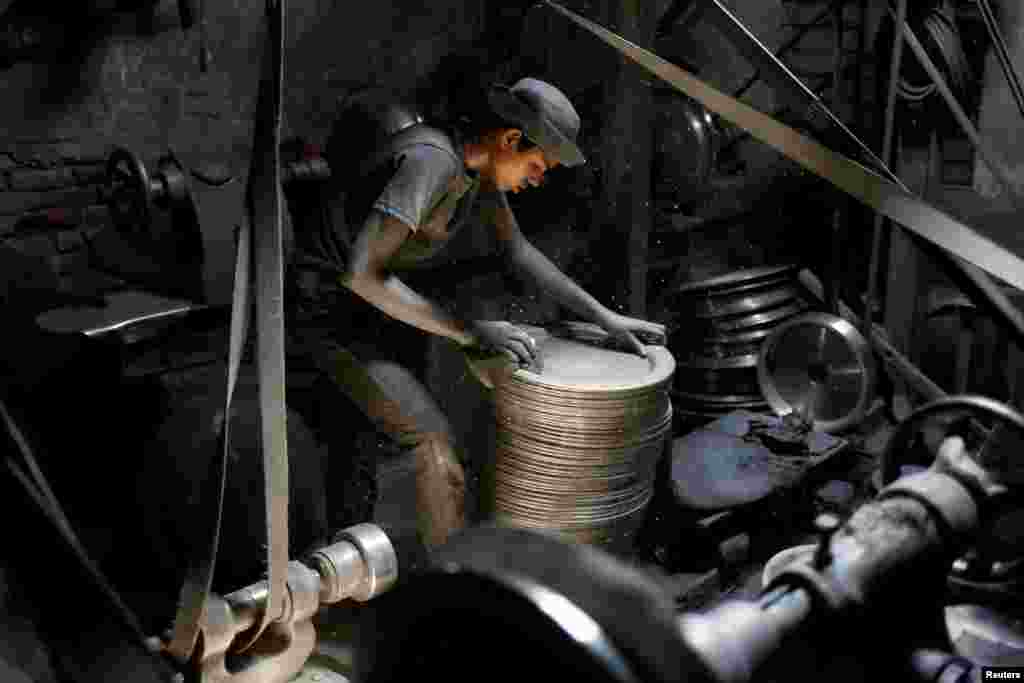 A boy works at an aluminum-utensils factory in Dhaka, Bangladesh, May 8, 2017.