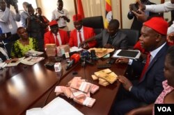 Members of the Ugandan opposition in Parliament address journalists as they return money given to them for consultations on the amendment of the Age Limit Bill, Oct. 25, 2017. (Halima Athumani for VOA)