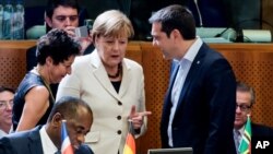 Greek Prime Minister Alexis Tsipras speaks with German Chancellor Angela Merkel at the European Union-Community of Latin American and Caribbean States summit in Brussels, June 10, 2015.