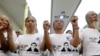 FILE - Friends and supporters wearing t-shirts with the image of lawyer Le Quoc Quan hold hands while attending a mass calling for Quan to be freed at Thai Ha church in Hanoi, Sept. 29, 2013. 