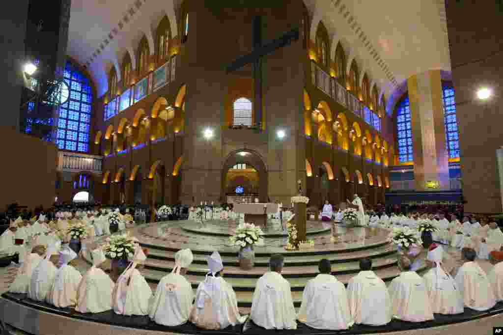 Members of the clergy listen to Pope Francis, center right, as he gives Mass inside Aparecida Basilica in Aparecida, Brazil.