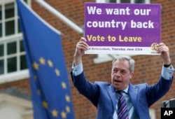 FILE - Nigel Farage, a British politician and leader of the UKIP party, holds up a placard as he launches his party's campaign for Britain to leave the European Union, outside the EU representative office in London, May, 20, 2016.