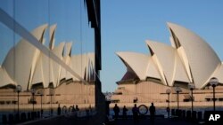 PAra pengunjung berjalan di tepi pantai Campbell Cove di Sydney, Australia, Rabu, 19 Mei 2021. (AP Photo / Mark Baker)