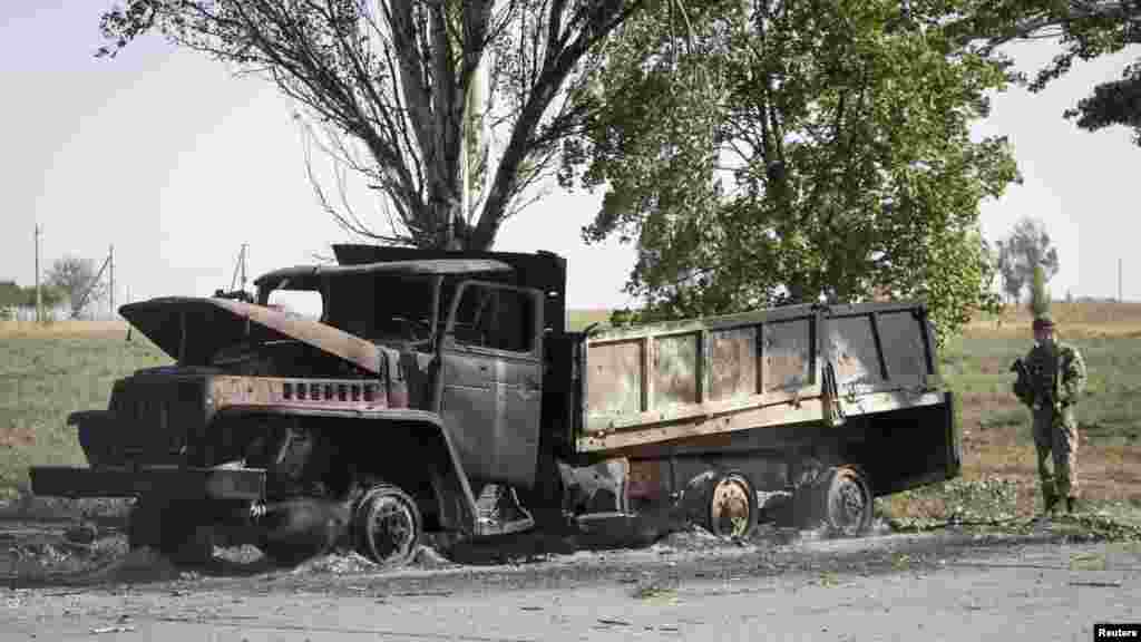 Seorang tentara Ukraina melihat sebuah truk yang terbakar dalam sebuah serangan di pinggir kota Mariupol, Ukraina (7/9).&nbsp;(Reuters/Vasily Fedosenko)