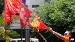 一名菲律宾退休警官在马尼拉焚烧中国国旗，抗议菲律宾人所说的中国侵犯领海行为。(资料照片)