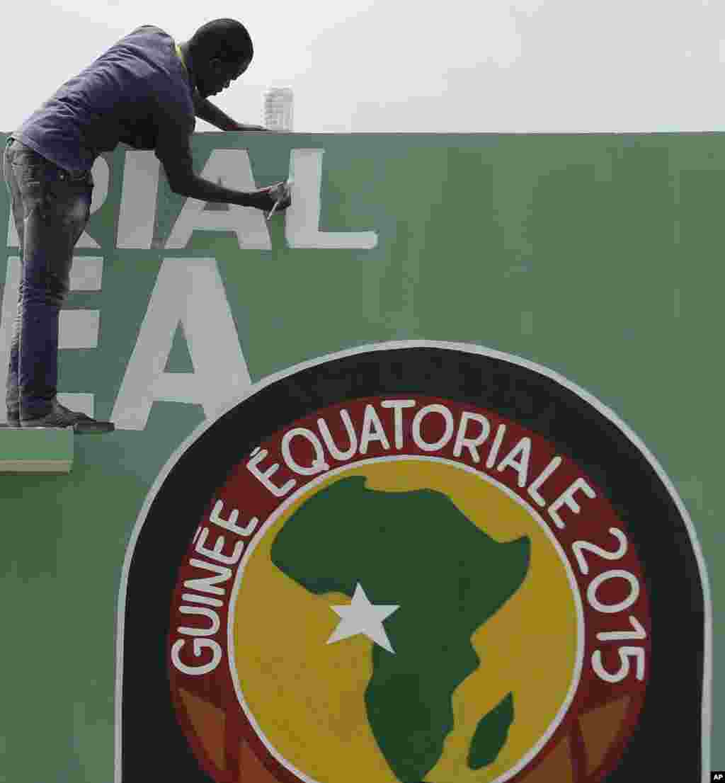 Un traveilleur passe un coup de peinture sur les écrits peints du mur avant l&#39;ouverture de la&nbsp;Coupe d&#39;Afrique des Nations&nbsp;samedi au stade de Bata, en Guinée équatoriale, le vendredi 16 janvier 2015.