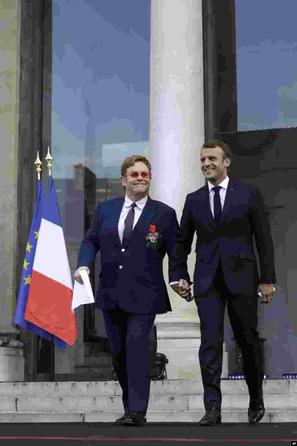 التون جان و امانوئل ماکرون در مقابل کاخ الیزه پس از اهدای نشان لژیون دونور فرانسه به خواننده سرشناس بریتانیایی.
