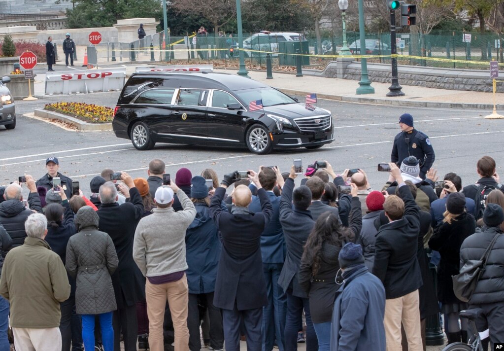 The hearse bearing the casket of former President George H.W. Bush leaves the Capitol on the way to a State Funeral at Washington National Cathedral, Dec. 5, 2018.