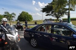 Pope Francis (center R) waves to well-wishers from the backseat of a car after his arrival in Naypyidaw, Myanmar, Nov. 28, 2017.