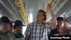 Sergei Polonsky was escorted by immigration police before he was deported from Cambodia, in a photo supplied by national police website. 